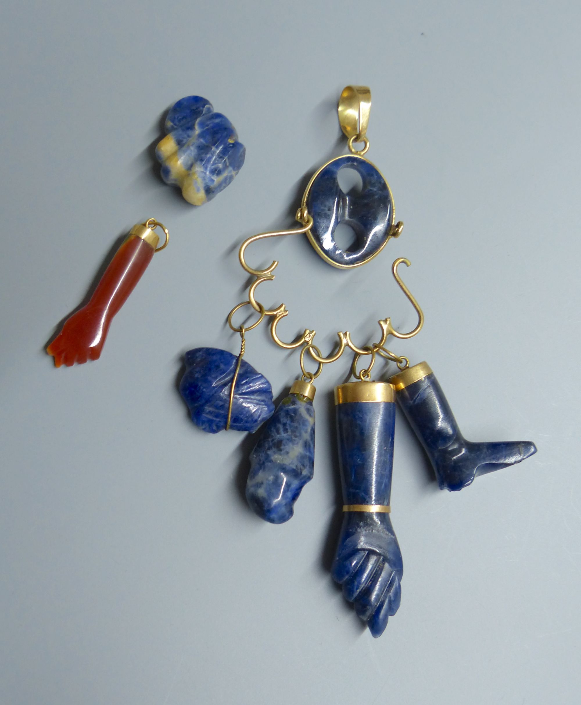 A continental 18k yellow metal and blue banded agate? set charm pendant, gross 25.6 grams, a similar pebble and an agate arm pendant